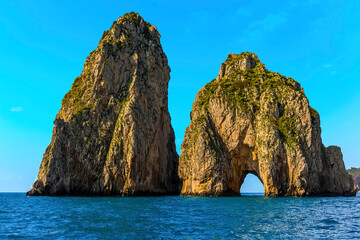 The tunnel of love sea arch beckons lovers sailing towards it on the Faraglioni rocks on the eastern side of the Island of Capri, Italy