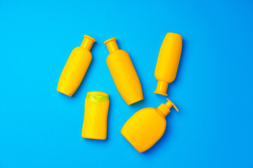 Bottles of sunscreen cream on blue background