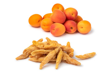 Heap of dried pitted sweet orange apricots and fresh apricots in the background