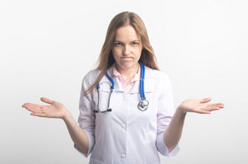 Confused tired young caucasian doctor with stethoscope isolated on white background after medical...
