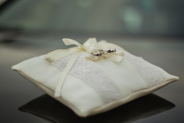 wedding rings on a white pillow