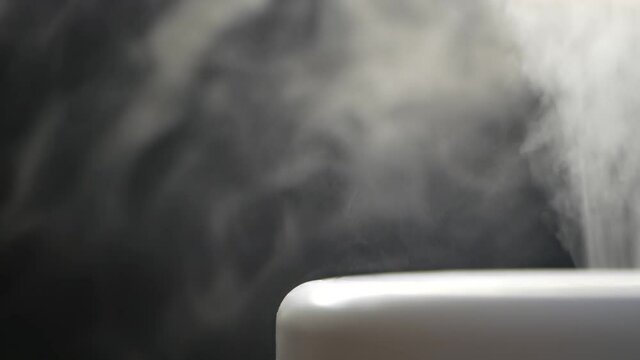 White steam of ultrasonic humidifier. Frume of vapor from diffuser for air moisturize. Loop endless video of smoke for humidity at home. Moisturizer and purifier of air. Diffused mist from inhaler.