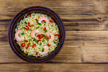 Instant noodle with shrimps, red pepper and green onion in a ceramic bowl. Japanese food. Top view