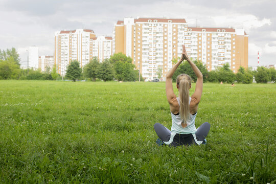 In the park, a woman practices yoga. Assans.
