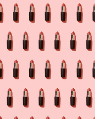 Obraz premium Red matte lipstick on a pink background in a black tube top view. Professional cosmetic product for the work of a makeup artist flat lay. Bright backdrop pattern