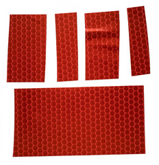 pieces of red glossy cloth gaffer tape stickers isolated on white background, red reflector stickers or snips, macro photo
