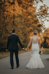 bride and groom walking in autumn
