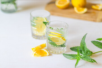 Top view of refreshing lemonade with slices of fruits in glass of drink with ice on white background for summer party. Summer drinks with ice
