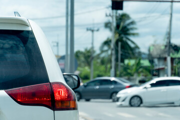 Transportation of white car on the road. Open light break waiting to release traffic signals. On the asphalt road. Many cars ran past the front.