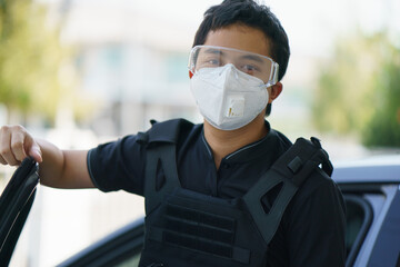 Man security guard wearing face mask, goggles and bullet proof outdoor.
