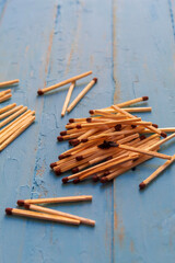A lot of wooden matches on a blue background, on one match before there was a fire
