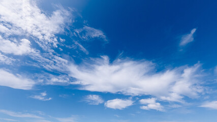 Naklejka na ściany i meble white cumulus clouds on a blue sky, bright sunny day, beautiful natural landscape