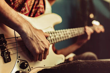 Close up of male hand playing electric guitar in the dark - obrazy, fototapety, plakaty