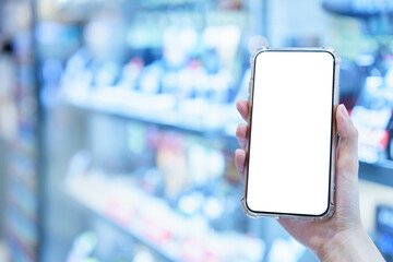 Mockup, hands holding blank white screen mobile phone in blurred camera display shop, digital payment concept