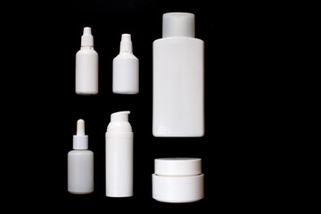 Simple Blank white Plastic Cosmetic Bottles Set.set of cosmetic products on a black background. Cosmetic package collection for cream, soups, foams, shampoo. Mock up white cosmetic bottles on black