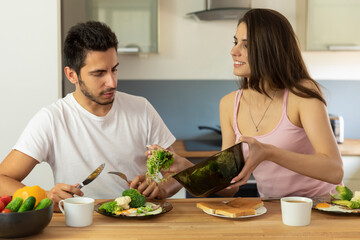 A young married couple having breakfast at home.
