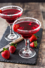Strawberry margarita cocktail in glass on wooden table.	