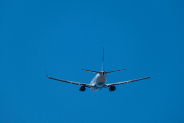 Plane in the sky. View from behind. Blue sky. Flight. Journey. 