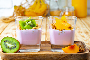 Berry youghurt with granola and fruits in a glass
