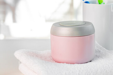 Cosmetic bottles against white bathroom wall background