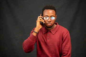 young black man with a straight face while making a phone call