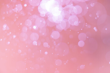 Abstract bokeh, defocused of water drops reflects light on pink gold background.