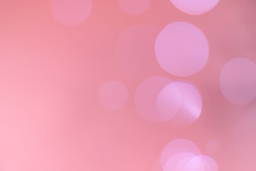 Abstract bokeh, defocused of water drops reflects light on pink gold background.