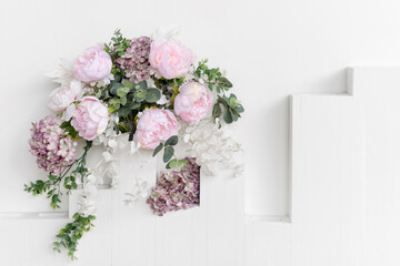 Flower wall, wedding backdrop, floral hand made decoration. Light background of artifical flowers. Vertical garden with peonies and hydrangeas. Elegant arrangement floristics setting. Copyspace.