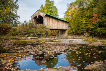 Fototapeta na wymiar The Montgomery Covered Bridge, also known as the Lower Covered Bridge is a wooden covered bridge that carries Montgomery Road across the North Branch of the Lamoille River in Waterville, Vermont