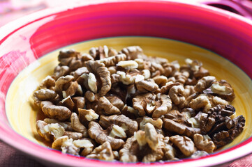 bright color plate with walnuts. Eco food. The shell of walnuts, clean of nuts