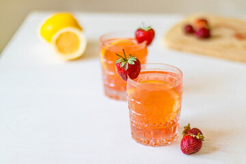 Lemonade with strawberries in glass on white background. Summer drinks with ice