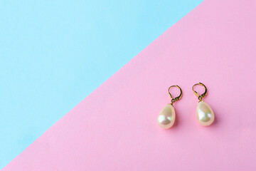 Vintage pearl jewelry earrings on pink blue background. Elegant gift for woman.