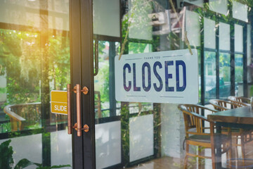 Text Closed door sign and hanging up on glass door of coffee shop .