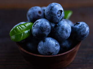 blueberries in a bowl on wooden background