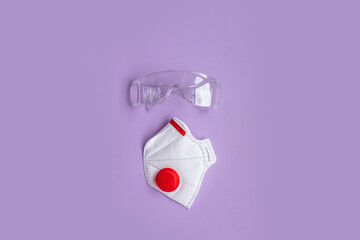 Medical protective mask, respirator ffp on purple background. Coronavirus, covid 19 prevention items.