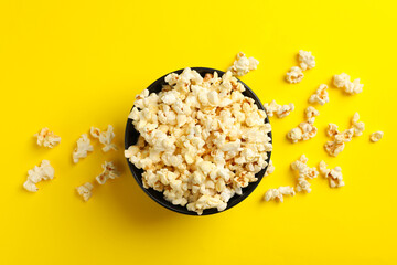 Bowl with tasty popcorn on yellow background. Food for watching cinema
