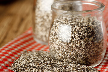 Glass bowl with chia seeds on wooden table