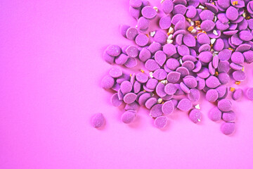 Pink chocolate drops scattered on pink background. Tablet for confectionary. Ruby chocolate made from ruby cocoa bean.