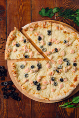 pizza with olives on wooden table in a restaurant