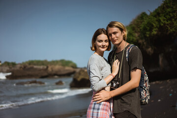 Obraz premium Young couple enjoy a trip together on the beach in the bright sunny day