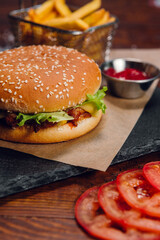 Burger with fries and ketchup on a table in a restaurant. Fast food, junk food