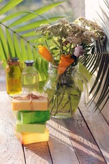 Soap, a bouquet of healing herbs in a glass jug on a wooden windowsill, natural cosmetics, the concept of a healthy lifestyle, homeliness and cleanliness