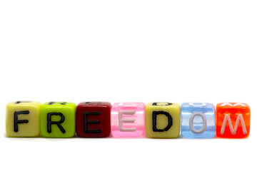 word freedom in rainbow colored cubes isolated on white background, heart symbol