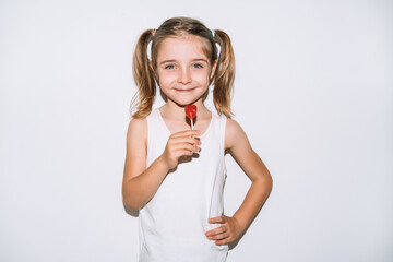 blonde girl smiling with a lollipop in her hands on a white background