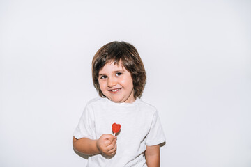 little boy smiling with a lollipop in his hands on a white background
