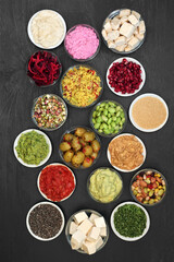 Vegan food for a healthy diet concept with foods high in protein, vitamins, minerals, anthocyanins, omega 3,  antioxidants, smart carbs and dietary fibre. Cruelty free food concept. Flat lay.