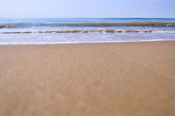 Fototapeta na wymiar waves with foam on tropical sandy beach. copy space