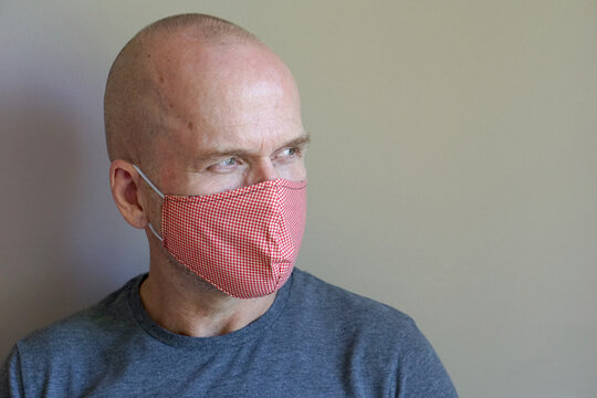 Caucasian man wearing gray T-shirt in reusable cloth mask for Flu epidemic, dust allergy, protection against virus. Covid-19, coronavirus pandemic
