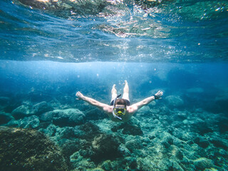 underwater scene of a diver. young guy dives into the sea. man snorkeling in the sea