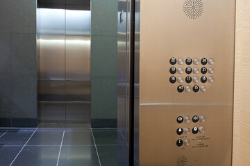 Inside elevator with door open looking across hall with adjacent elevator door also open in high-rise building © Dennis M. Swanson